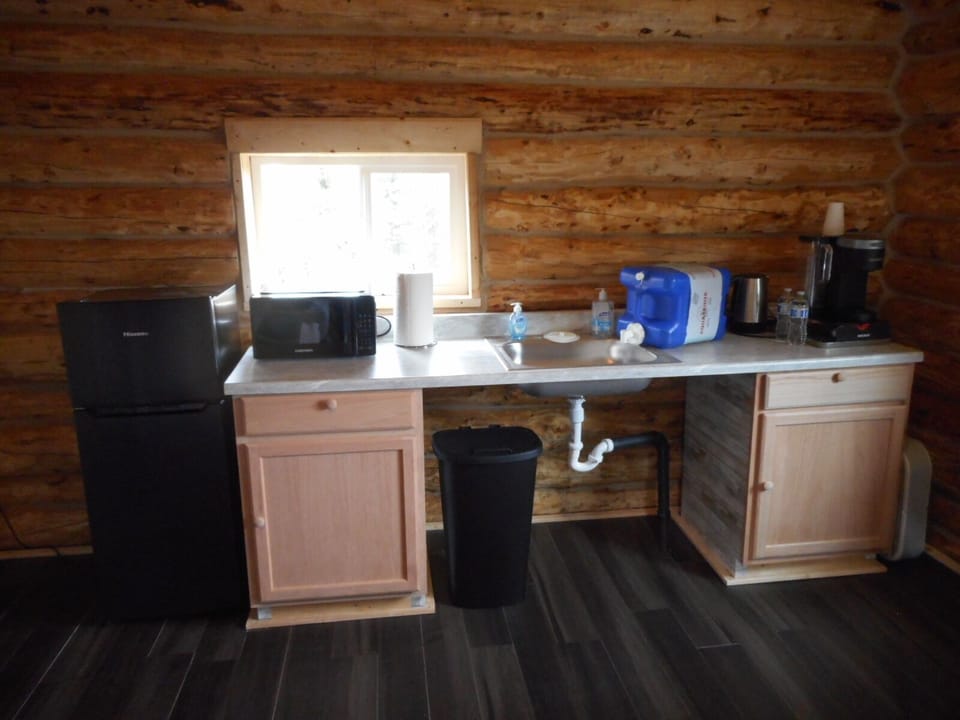  Refrigerator, microwave, dry sink, 5gals water jug, coffee maker, trash can.