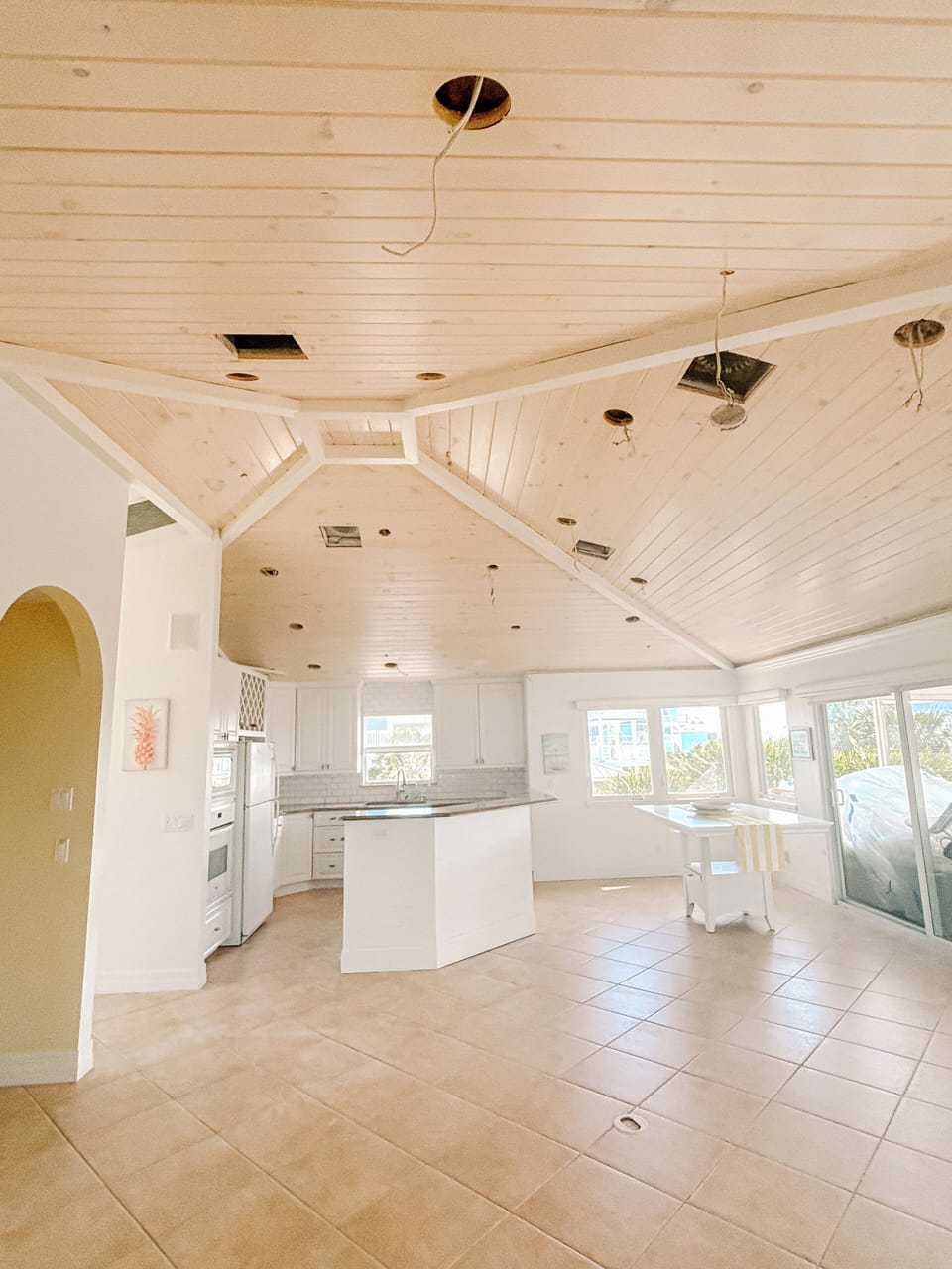 Freshly painted living room/kitchen with new, planked ceiling.