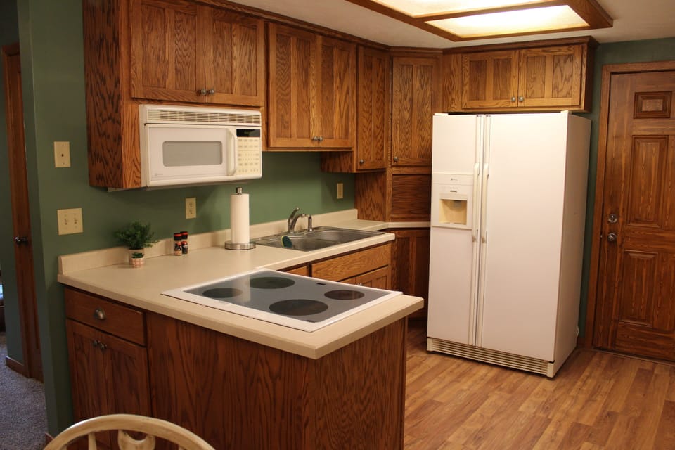 Kitchen with pots and pans, plates, coffee maker, culligan drinking water