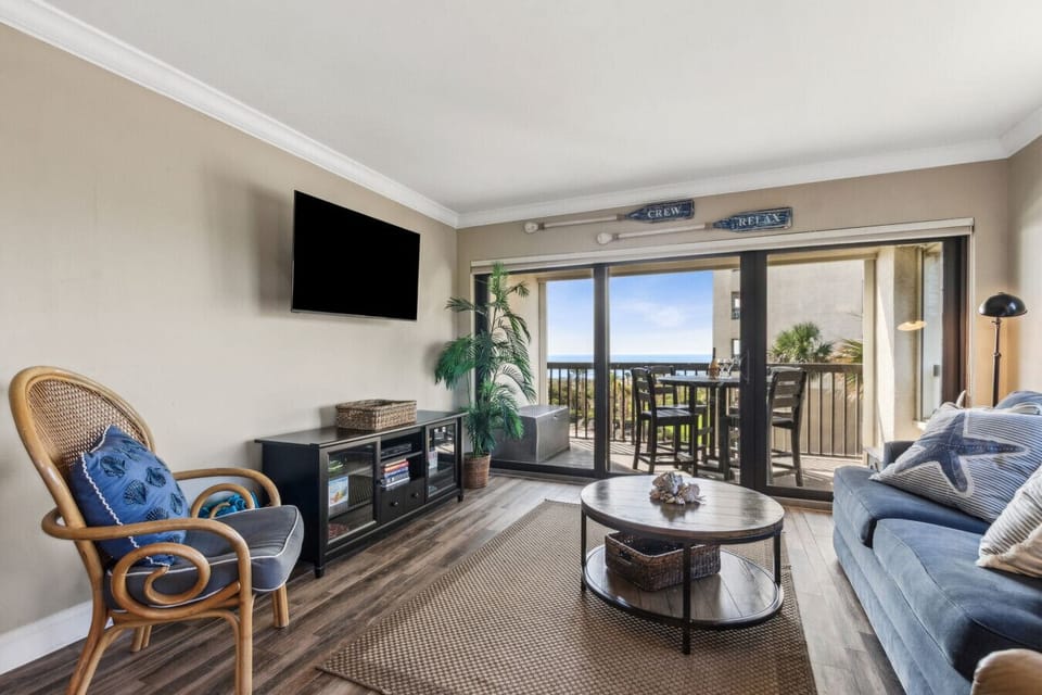 Living room with cable tv and sliding glass door to balcony