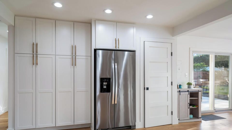 Sleek double-door fridge meets secret laundry nook to the right, modern style and full convenience.