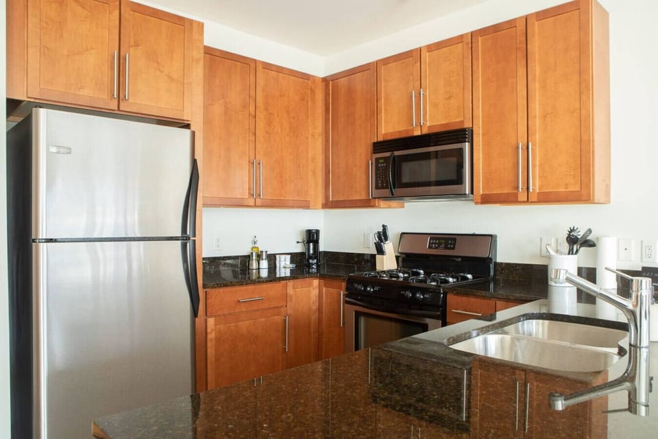 The full modern kitchen features stainless steel appliances and bar stool seating, making it easy to whip up morning breakfast or entertain your group