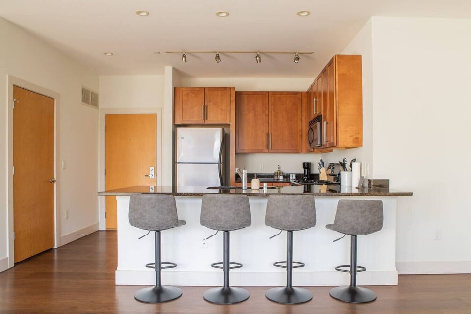 The full modern kitchen features stainless steel appliances and bar stool seating, making it easy to whip up morning breakfast or entertain your group