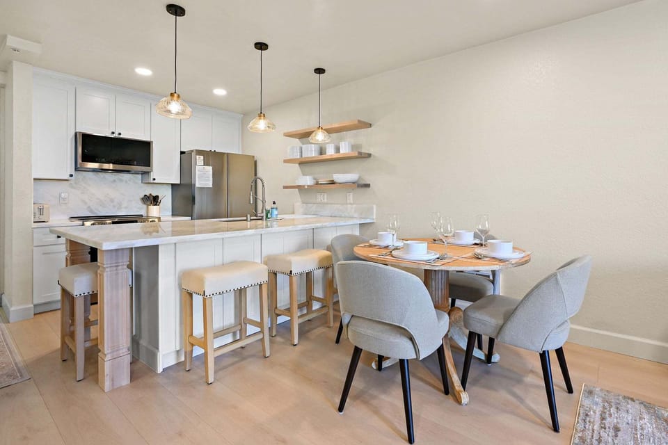 A stunning wooden dining table that seats four, complemented by four additional seating at the kitchen island.