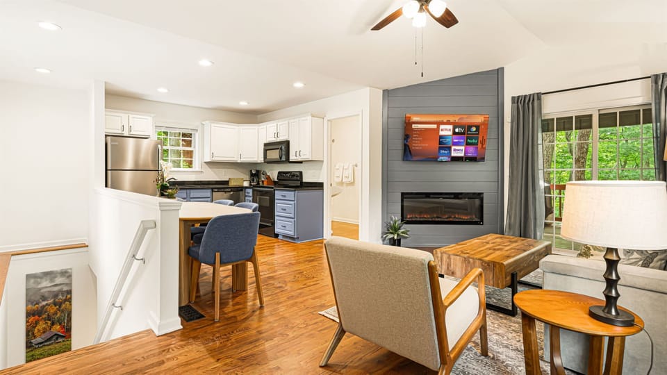 The whole main level opens up in front of you — kitchen, dining, living room, and the slider door to the deck, all in one easy flow.