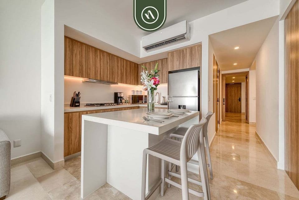Sleek white waterfall island with contemporary barstools standing at the entrance of a modern kitchen.