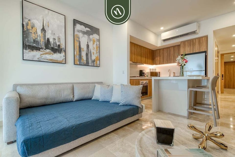 Looking across the grey sofa toward a white kitchen breakfast bar with modern barstools.