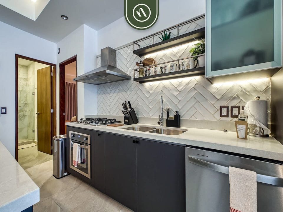 Modern Kitchen
Fully equipped chef's kitchen with sleek countertops, gas stove, stainless appliances, and bar seating, ideal for cooking or casual dining.
