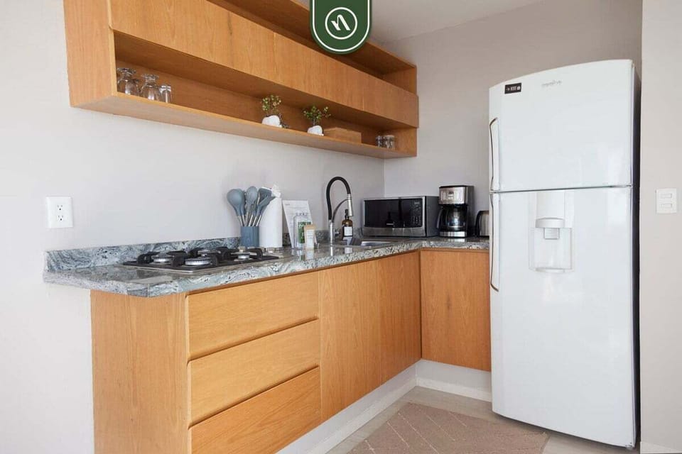 Cook with ease in this sleek, contemporary kitchen. Featuring ample counter space, a full-sized refrigerator, and all the essentials you need to feel right at home.