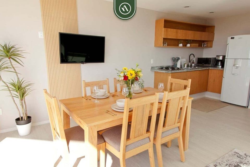 Gather for meals in this inviting open space. The large wooden dining table and well-equipped kitchen make it easy to enjoy everything from quick breakfasts to formal dinners.