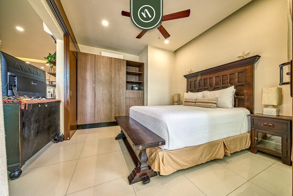 An alternative view of the bedroom highlighting the solid wood furnishings, TV stand, and generous closet space.