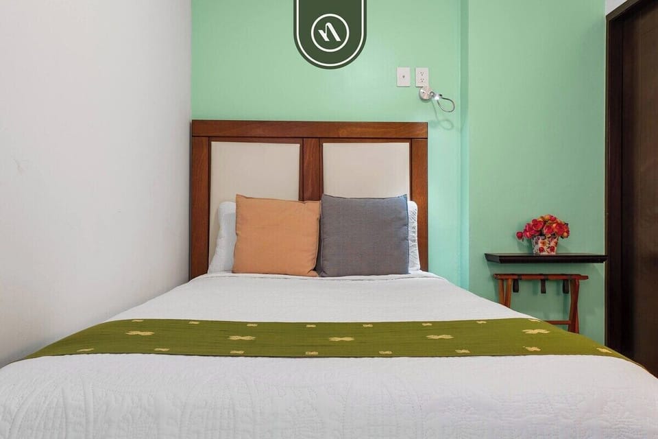 Enjoy a restful sleep in this inviting bedroom. It features a comfortable bed, vibrant local touches, warm wooden accents, and a relaxing atmosphere.