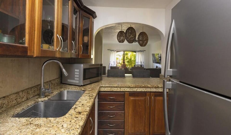 Prepare your favorite meals in this classic kitchen, complete with ample granite counter space, rich wooden cabinetry, and modern stainless steel appliances.