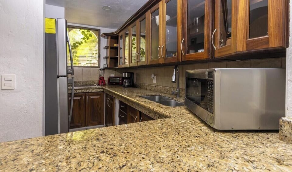Cook with ease in this fully equipped kitchen. It offers abundant granite counter space, beautiful wooden cabinets, and the essential appliances you need to feel right at home.