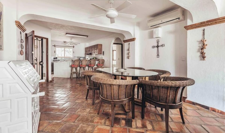 An alternate view of the dining layout, showcasing white walls accented with rustic decor and arched details.