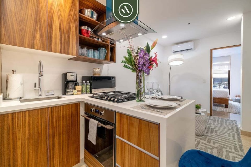 Cook in style with this contemporary kitchen, featuring rich wood cabinetry, high-end stainless steel appliances, and a gas range. The open layout and breakfast bar make it a perfect hub for dining and entertaining.
