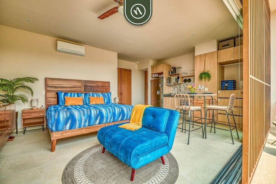 Bright and inviting studio layout combining sleeping, dining, and living spaces for a comfortable and functional stay.