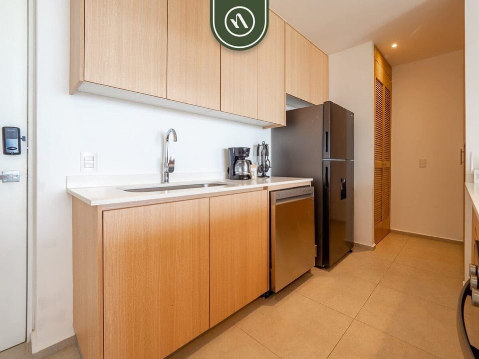 Streamlined cabinetry houses a full-sized refrigerator, microwave, and dishwasher. This clean, functional space is perfect for everything from snacks to full meals.