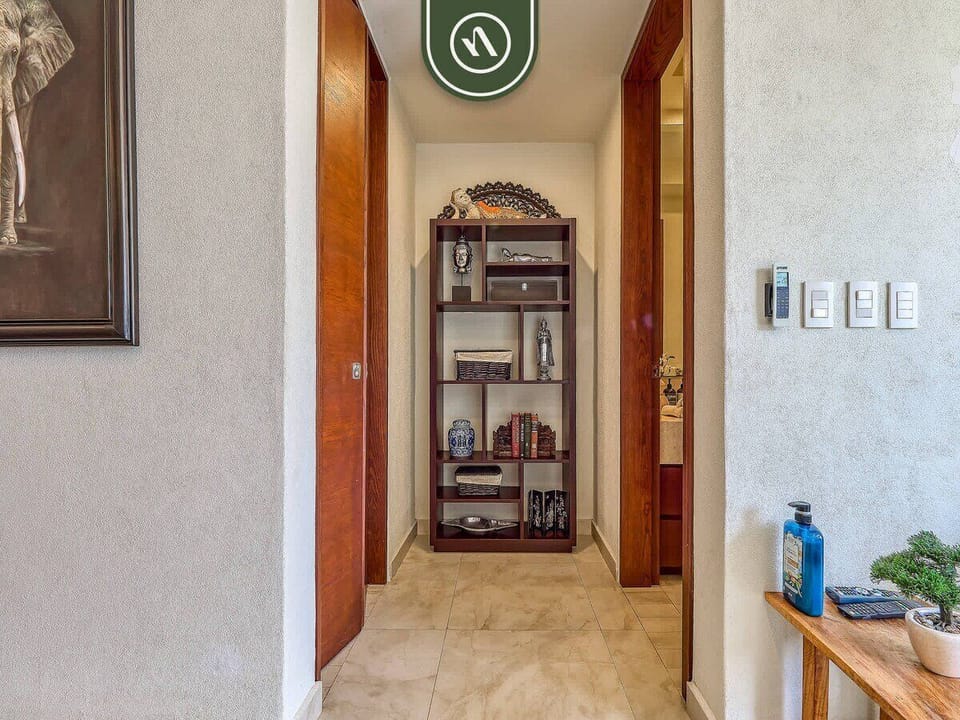 Move seamlessly through the home's warm corridors. The hallway features beautiful solid wood doors and a custom decorative bookshelf that adds a personalized, homey touch to the space.