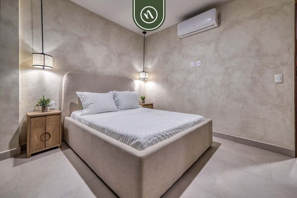Recharge in a serene bedroom with premium linens, modern finishes, and air conditioning for a comfortable stay.