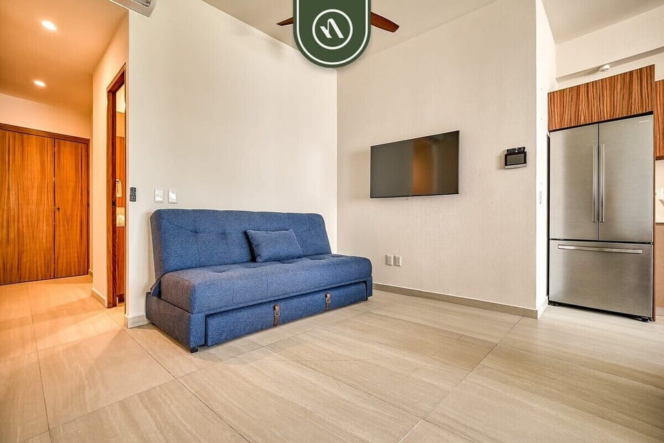 Unwind in the bright open-concept living space featuring comfortable seating, a smart TV, and seamless access to the kitchen and dining area.
