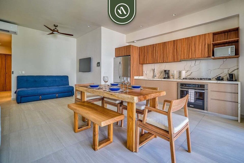 Gather, dine, and relax in this spacious open-concept area combining a modern kitchen, dining table, and cozy lounge space.