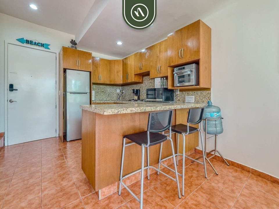 Cook with ease in this functional kitchen featuring warm wood cabinetry and sleek granite countertops. The breakfast bar with seating for two makes it a perfect spot for quick meals or a morning coffee.