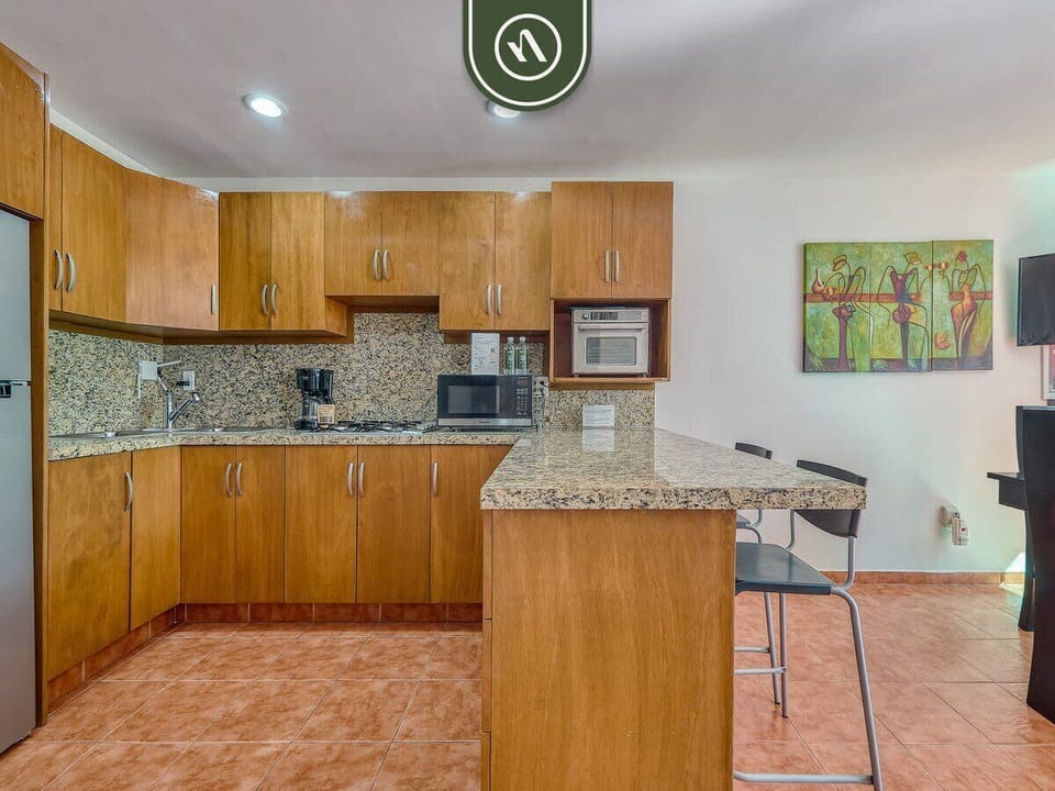 A comprehensive view of the wrap-around kitchen. Featuring ample wooden cabinetry, modern appliances, and generous counter space, it has everything you need to feel right at home.