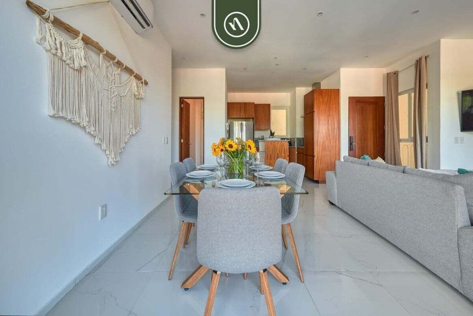 Share meals at this chic glass dining table with seating for six. A beautiful macrame wall hanging adds a touch of bohemian charm.