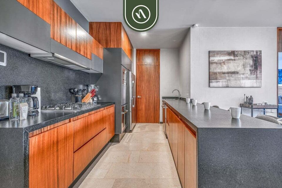 Modern kitchen layout showcasing premium wooden cabinetry, dark granite countertops, and a parallel breakfast bar.
