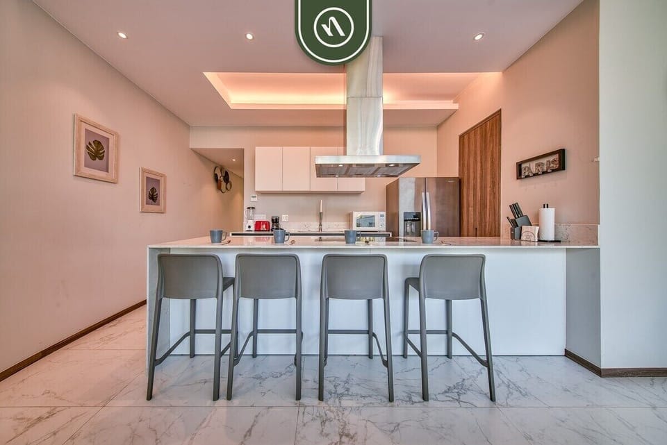 Prepare meals with ease in the fully equipped kitchen featuring sleek finishes, spacious countertops, and convenient bar seating.