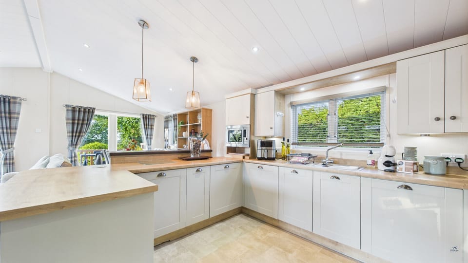 Well-equipped open-plan kitchen with dishwasher, coffee machine and air fryer.
