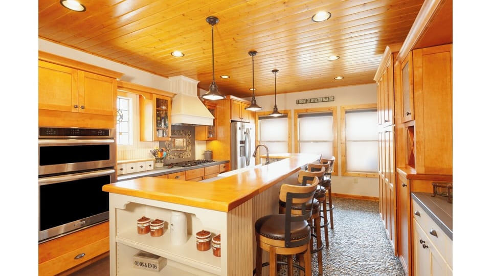 Step into your dream culinary space with rich wood cabinetry, a spacious island for meal prep, and modern stainless appliances ready for your gourmet creations.