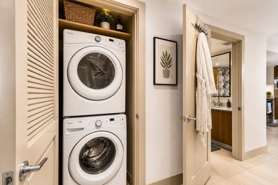 In-unit stacked washer and dryer tucked behind a mirrored closet door — no laundromat runs needed.