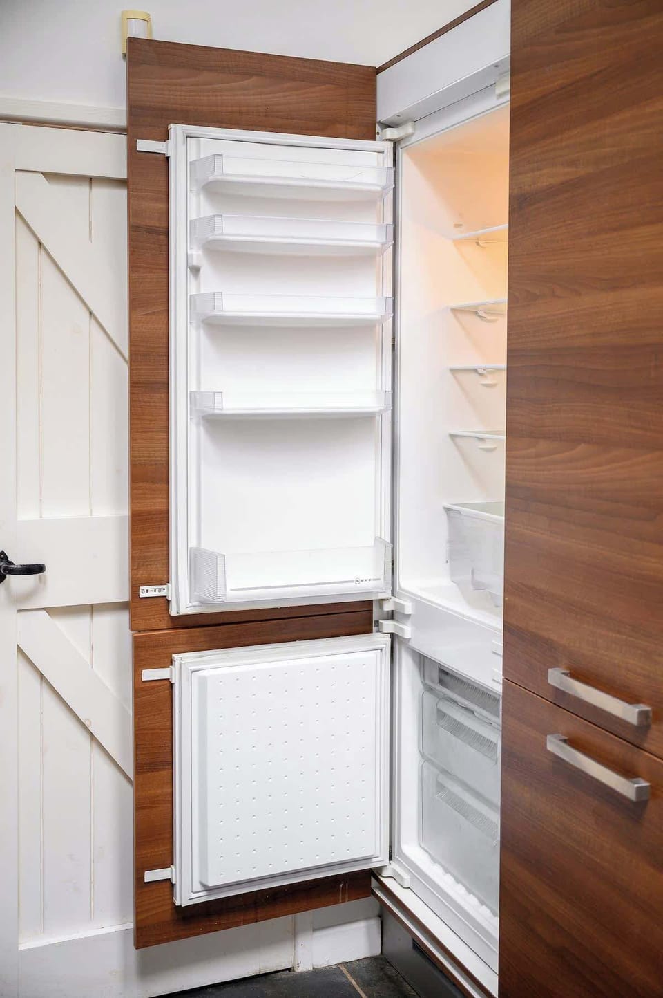 Integrated full-size fridge freezer tucked behind wooden cabinetry so you can stock up for your stay