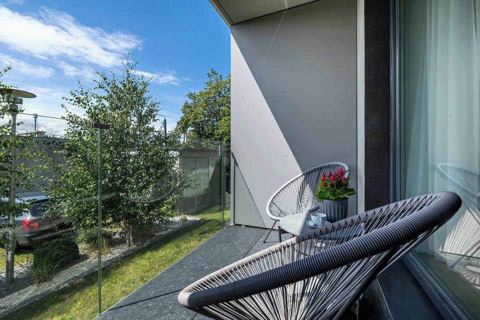 A balcony with two chairs and a view of the lawn. A quiet place to relax outdoors.