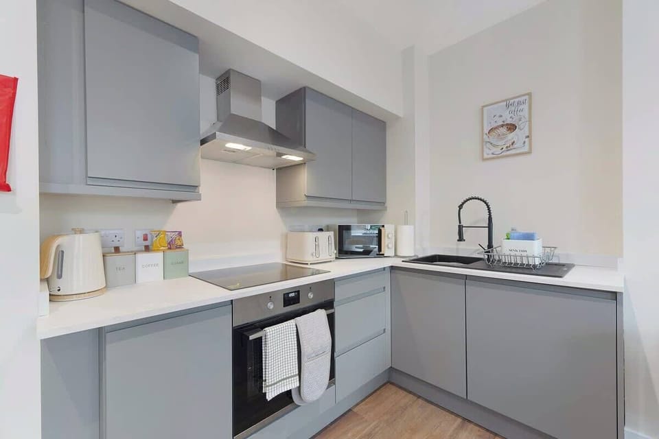 Kitchen equipped with all essentials, including a microwave, kettle, toaster, and full cookware set.