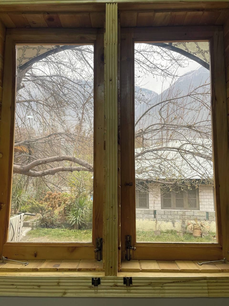 Traditional wooden windows opening to peaceful scenery.