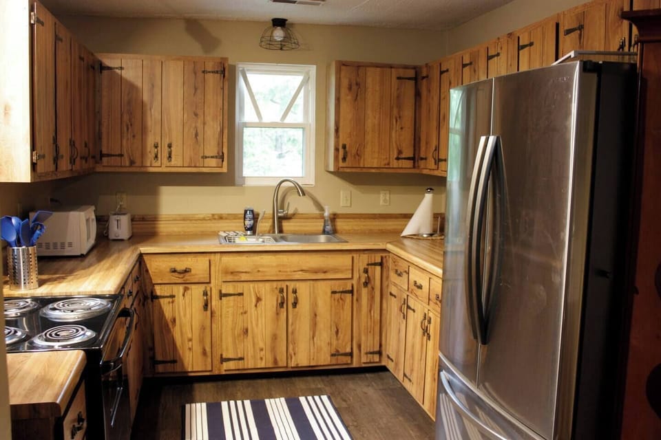 Rustic kichen with full size refrigerator stocked with water and has an automatic ice maker