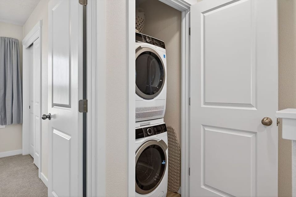 A laundry closet equipped with a stacked washer and dryer.