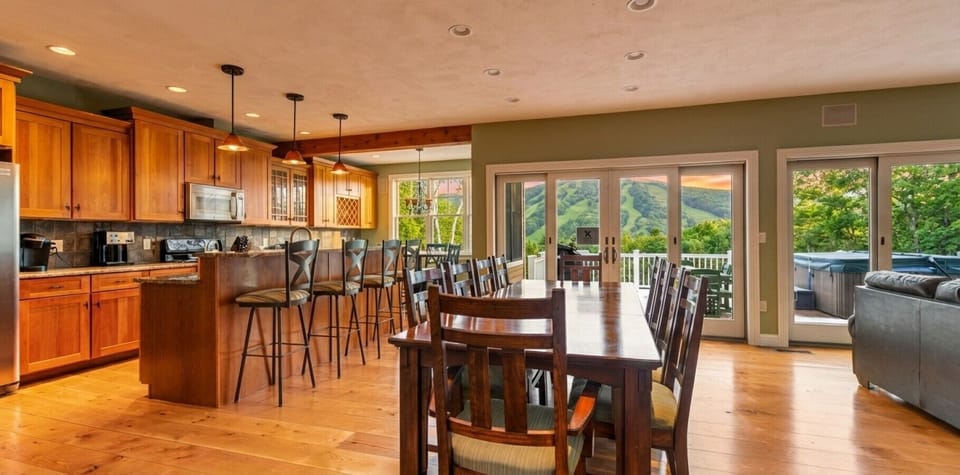 Enjoy family meals with this 10-person dining table next to the living room along with views of Mount Snow in the back