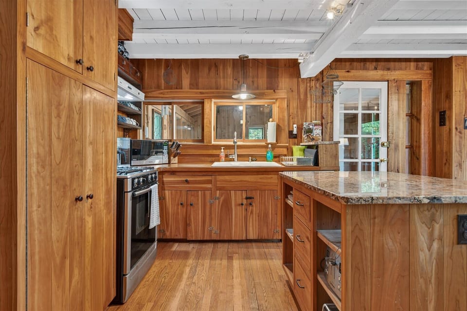 Cook like a local in this warm, wood-paneled kitchen—complete with modern appliances and cozy vibes.