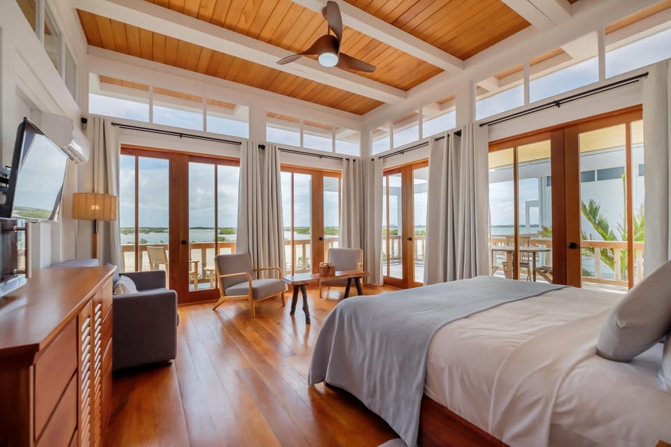 Wake to panoramic windows and soft linens in this airy suite.