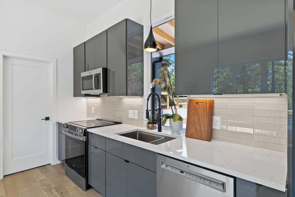 Deep farmhouse sink with forest-view window.