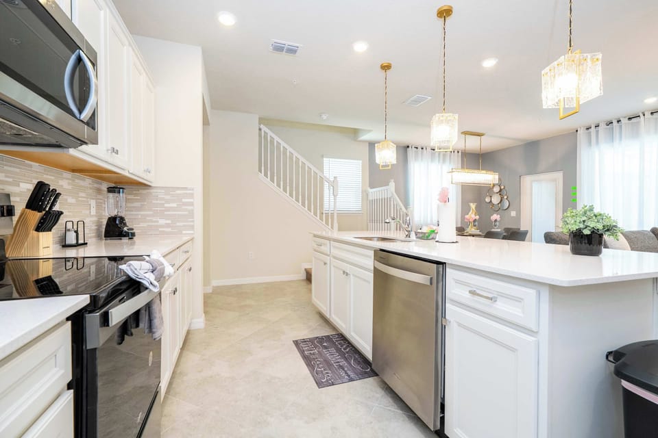 Enjoy an open-concept kitchen with sparkling quartz counters, modern pendant lights, and easy flow into the bright, inviting living area and dining space.