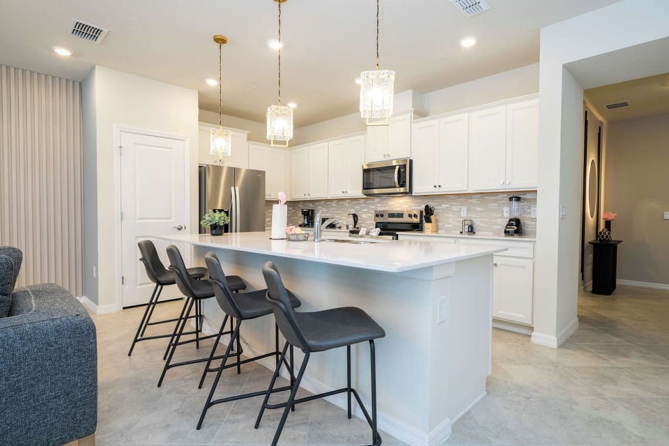Pull up a seat at the spacious breakfast bar in this modern kitchen, complete with chic lighting and plenty of room for group gatherings!