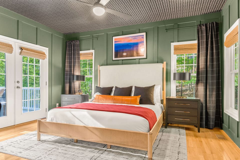 Wake refreshed in this serene main-level primary suite featuring an award-winning Helix king mattress, ensuite bath, workspace, walk-in closet, and direct front-deck access with mountain views.