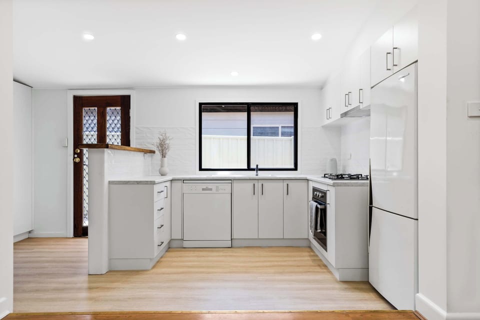 Fully equipped, light and bright kitchen featuring full size appliances including dishwasher and an abundance of storage space.