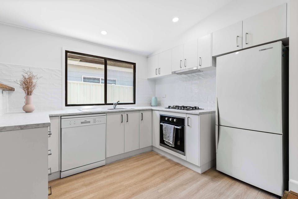 Fully equipped, light and bright kitchen featuring full size appliances including dishwasher and an abundance of storage space.