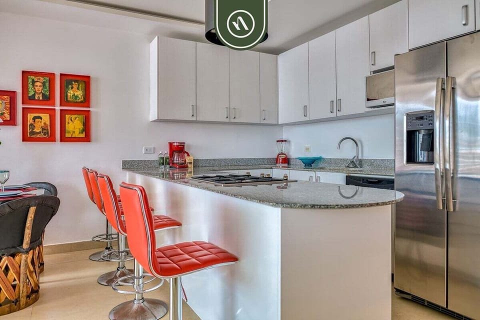 Cook up a feast in this sleek kitchen. It boasts stainless steel appliances, granite countertops, and a fun breakfast bar with bright red stools for casual dining.